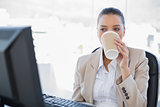 Relaxed sophisticated businesswoman drinking coffee