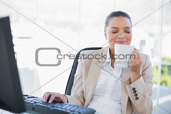 Smiling sophisticated businesswoman smelling coffee