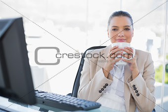 Relaxed sophisticated businesswoman smelling coffee