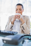 Peaceful sophisticated businesswoman smelling coffee