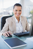 Cheerful sophisticated businesswoman working on computer