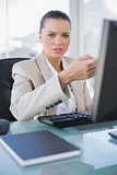 Worried sophisticated businesswoman working on computer