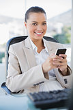 Smiling sophisticated businesswoman text messaging