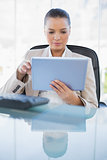 Focused sophisticated businesswoman holding tablet computer