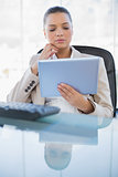 Concentrated sophisticated businesswoman holding tablet computer