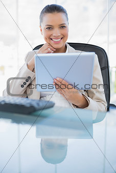 Smiling sophisticated businesswoman holding tablet computer