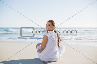 Rear view of smiling woman looking over shoulder at camera