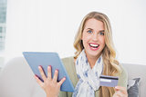 Smiling pretty blonde using her credit card to buy online