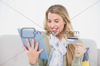 Happy pretty blonde using her credit card to buy online