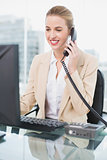 Smiling pretty businesswoman answering the phone