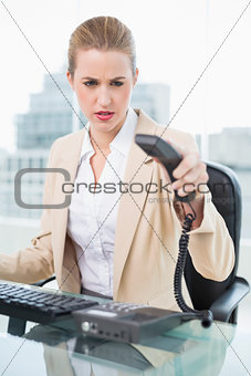 Angry pretty businesswoman hanging up the phone