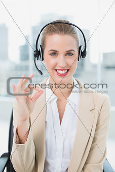 Smiling pretty call centre agent giving okay gesture