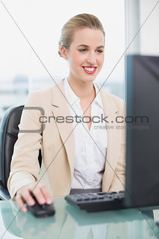 Cheerful attractive businesswoman working on her computer