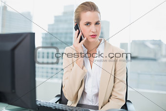 Stern attractive businesswoman on the phone