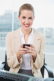 Cheerful attractive businesswoman text messaging
