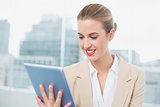 Smiling attractive businesswoman using her tablet