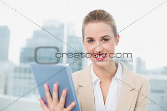 Cheerful attractive businesswoman using her tablet