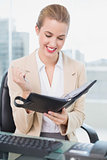 Smiling attractive businesswoman holding her agenda