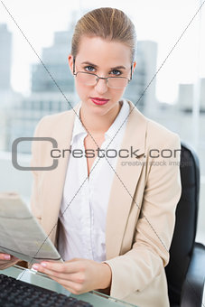 Serious businesswoman holding newspaper