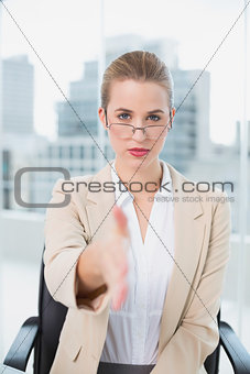 Serious businesswoman with glasses presenting her hand