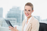 Cheerful businesswoman with glasses using calculator
