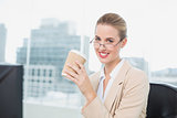 Cheerful businesswoman with glasses holding coffee