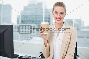 Smiling businesswoman with glasses holding coffee