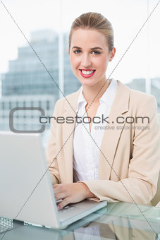 Cheerful businesswoman working on her laptop