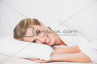 Smiling cute model lying on cosy bed