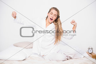 Yawning pretty model stretching in cosy bed