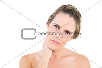 Upset woman looking at camera with a sore neck