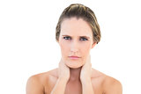 Disgruntled woman looking at camera with a sore neck