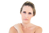 Disgruntled woman looking at camera with a sore shoulder