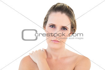 Disgruntled woman looking at camera with a sore shoulder