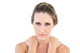 Frowning woman looking at camera with sore shoulders