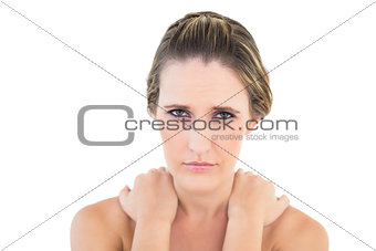 Frowning woman looking at camera with sore shoulders
