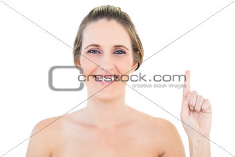 Smiling woman pointing up and looking at camera