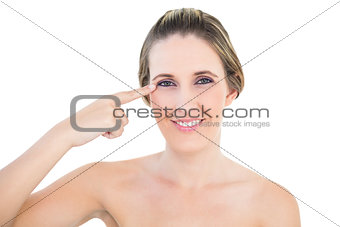 Smiling woman pointing at her eye