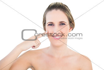 Smiling woman pointing at her cheek