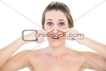 Shocked woman pressing blackhead on her nose