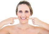Smiling woman pointing at wrinkle on her mouth corners