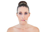 Sick woman with thermometer on mouth looking at camera