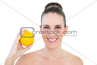 Happy woman holding orange