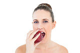 Pretty woman eating apple looking at camera