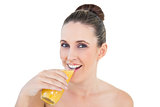 Woman drinking orange juice looking at camera