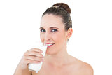 Happy woman drinking milk and looking at camera