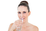 Woman drinking water looking at camera
