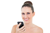 Smiling woman holding phone looking at camera