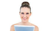 Smiling woman holding tablet looking at camera
