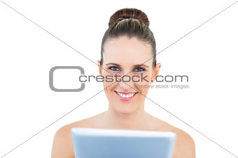 Smiling woman holding tablet looking at camera